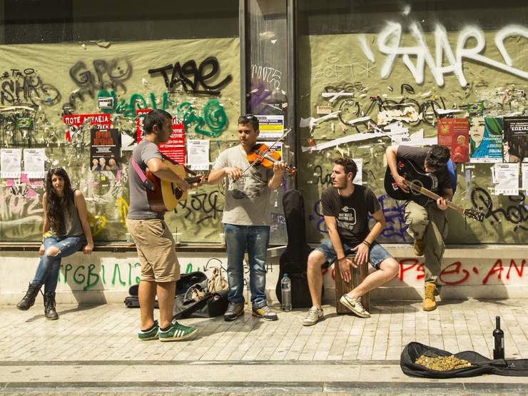ATHENS, GREECE - MAY 10, 2014: Unidentified street musicians play for tourists. Tourism is a decisive sector of hope for Greek economy - In the year Greece receives about 18 million tourists.