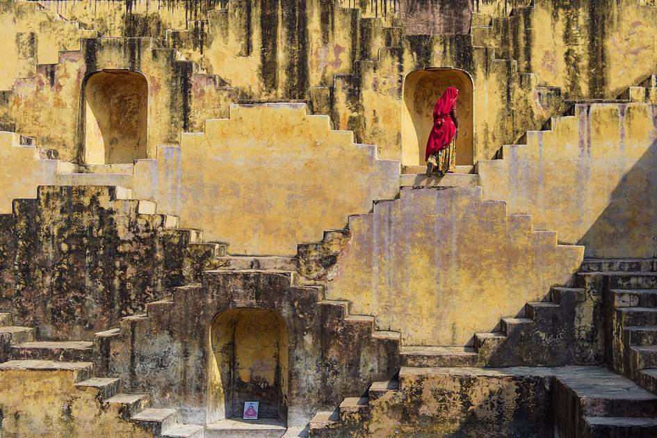 Local Women crossing the stepwells of Chand Baori, in Jaipur, India. 