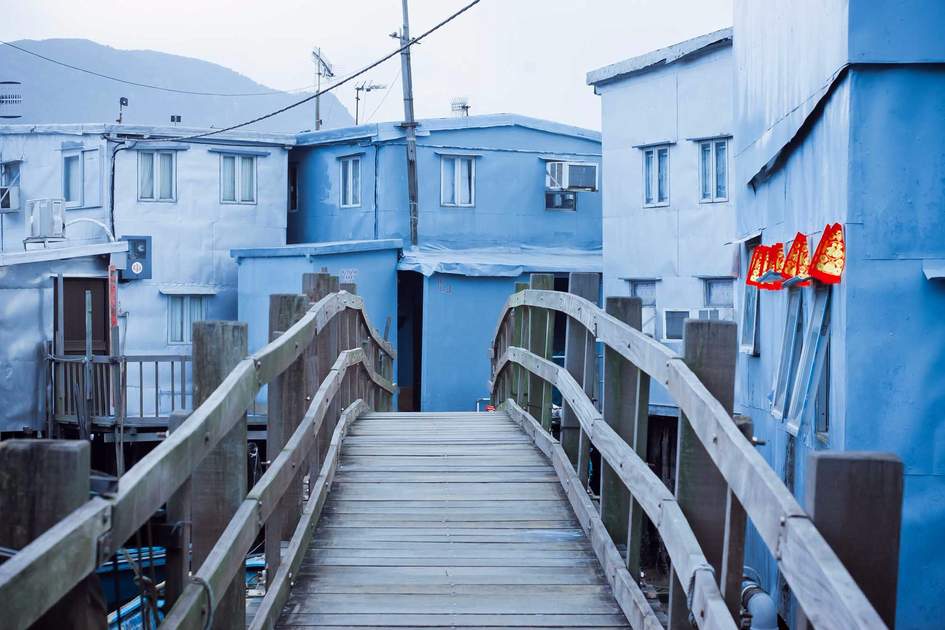 Wooden bridge to small homes made from iron, aluminum houses stand on wooden stilts in the village Tai O, Hong Kong